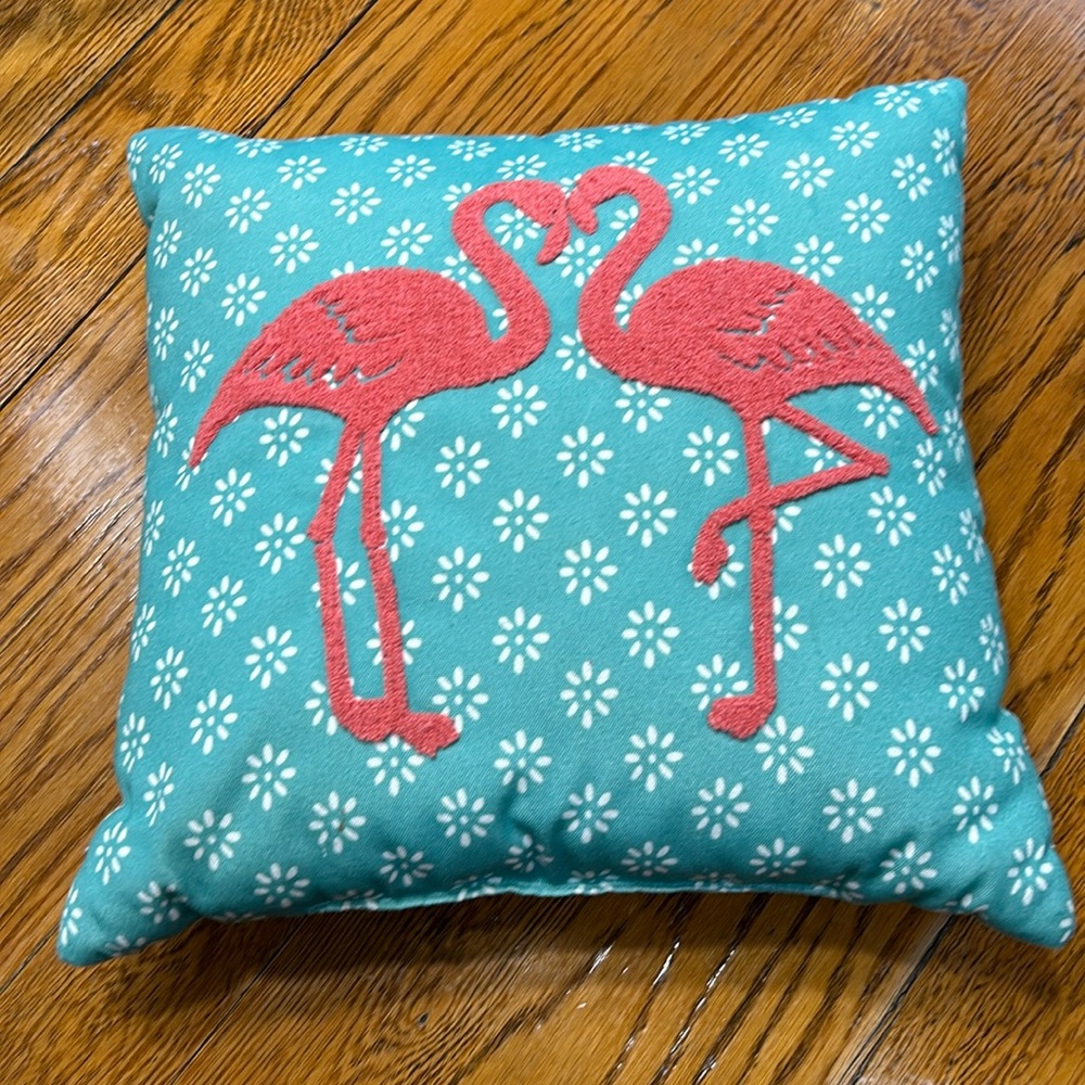 Aqua fabric pillow with hook and loop flamingo decoration.